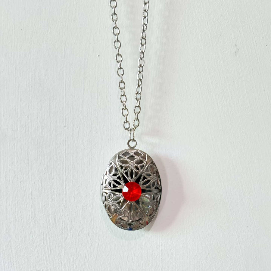 Filigree locket with red crystal