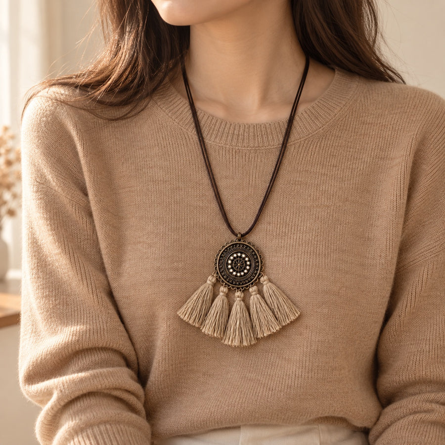 Medallion Tassel Necklace worn with a camel knit sweater (styling image, clothing not included)