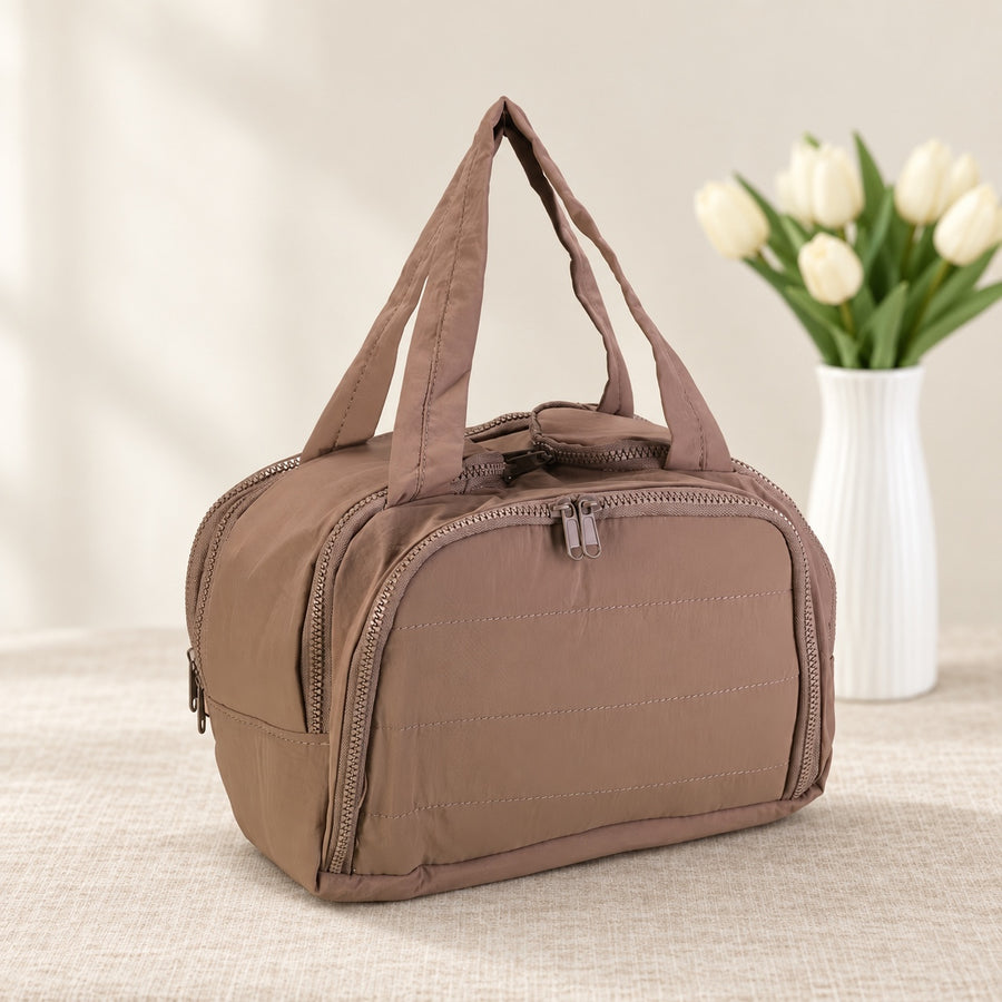 Travel makeup organizer bag in Coffee on an ivory linen tabletop