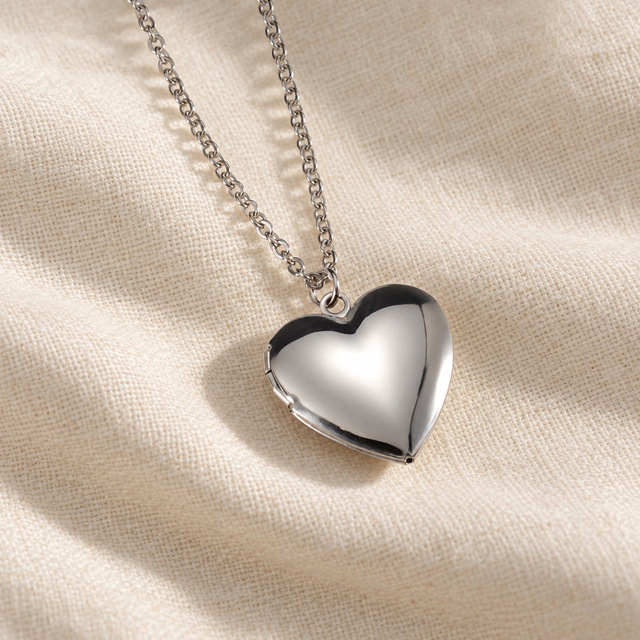 Silver heart photo locket necklace on ivory linen