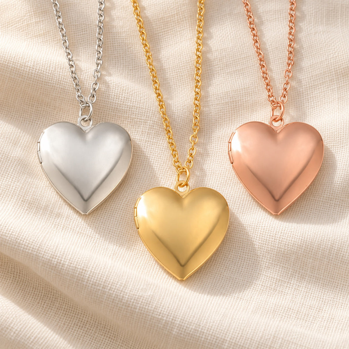 Heart photo locket necklaces in silver, gold and rose gold on ivory linen